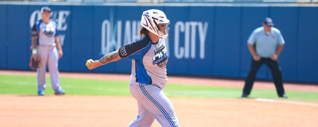 Softball pitcher throwing during a game on a turf field, representing slow pitch softball Seattle Tacoma.
